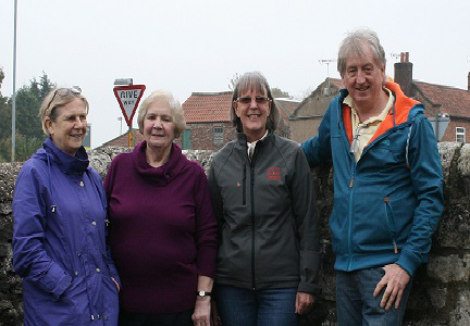 committee standing outside in front of a wall